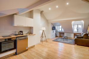 an open kitchen and living room with a couch at Apparts de l'Oncle Louis in Versailles
