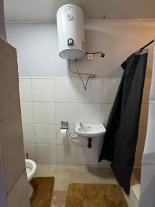 a small bathroom with a toilet and a sink at Elimisam cabin in Kitwe