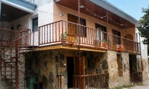 a house with a balcony on the side of it at Sunny in Mestia