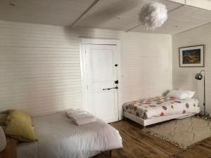 a bedroom with two beds and a door and a lamp at Castel La Fabrik'Créative in Saint-Barthélémy-dʼAgenais +8 photos