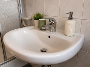 a white sink with two cups on top of it at Messeappartementhaus Bockenem direkt an der A7 in Bockenem
