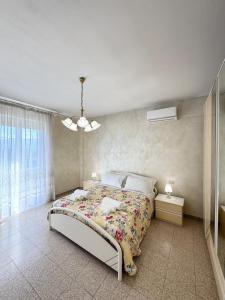 a bedroom with a bed with a floral bedspread at Mare e Monti a 5 minuti dal mare in Furnari