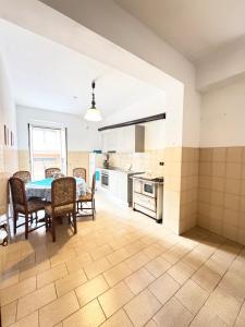 a kitchen with a table and chairs in a room at Mare e Monti a 5 minuti dal mare in Furnari