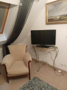 a living room with a chair and a television at Chambre Ploeren in Ploeren