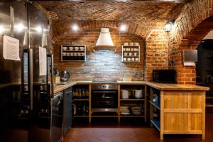 a kitchen with a brick wall and a refrigerator at Gospodarstwo nad jeziorem in Załom