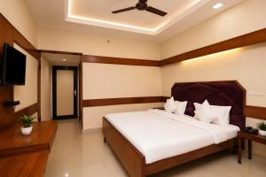a bedroom with a bed and a flat screen tv at Natraj in Bilāspur
