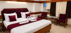 a bedroom with a large bed with two towels on it at Natraj in Bilāspur