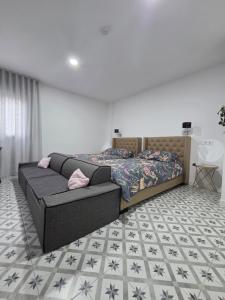a bedroom with a bed and a couch at LAS CASITAS DE JISA in Talavera de la Reina