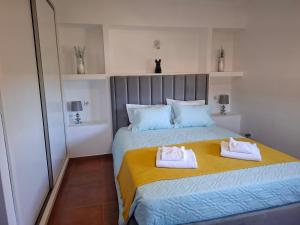 a bedroom with a bed with two towels on it at Casa do Diniz in Travassos +25 photos