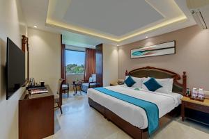a hotel room with a bed and a television at Hotel Suba Palace Near Gateway of India in Mumbai +38 photos