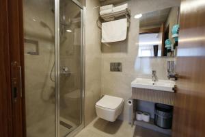 a bathroom with a shower and a toilet and a sink at Kalkan Hotel in Istanbul +37 photos