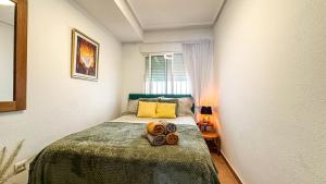 a small bedroom with a bed with two towels on it at NEW Villa Cabo Roig Coco-Mat 2 in Playas de Orihuela +36 photos