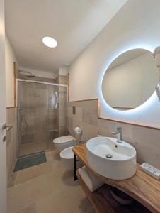 a bathroom with a sink and a shower and a toilet at NUX Rooms & Garden in Veglie