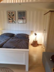 a bedroom with a white bed and a lamp at Chalet Ritz Ferienhaus in Dieblich +9 photos