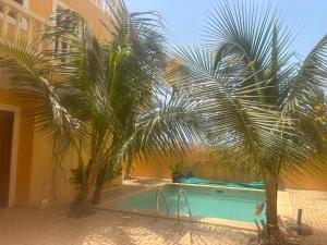 a swimming pool with two palm trees next to a building at Casa de los Encantos in Vila do Porto