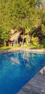 a swimming pool with blue water in front of a house at Chalet Ritz Ferienhaus in Dieblich