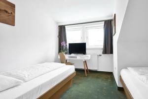 a room with two beds and a desk with a computer at Alpina`s Beds & Boots in Obertauern
