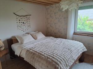 a bedroom with a bed with a white comforter and a window at Tuule in Jeedasküla