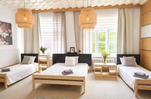 a bedroom with two beds and two chairs at Pasta Kvartāls Inn in Ogre