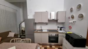 a small kitchen with white cabinets and a sink at Casetta Mary in Teramo +5 photos