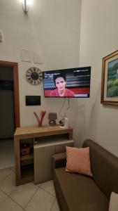 a living room with a couch and a tv on the wall at Casetta Mary in Teramo