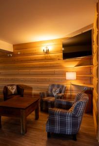 a living room with two chairs and a flat screen tv at Willa na Borku in Ciche
