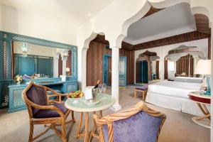 a hotel room with a bed and a table and chairs at Hotel Excelsior Venice in Venice-Lido