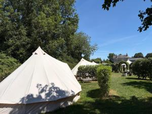 a group of tents in a field with trees at Camping at the Barge in Alton Barnes
