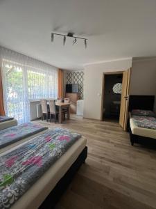 a bedroom with two beds and a dining room with a table at Baracuda in Dębki