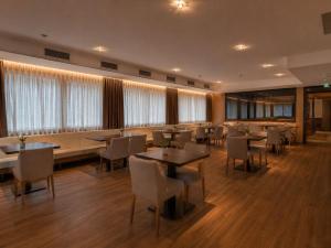 a dining room with tables and chairs and windows at Leni-Marie Saalbach in Saalbach-Hinterglemm