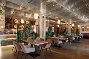 a dining room with tables and chairs and plants at Hotel Chateau Cojusna in Cojuşna