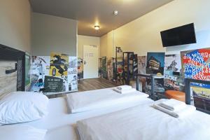 a hotel room with two beds and a tv at a&o Stuttgart City in Stuttgart