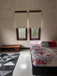 a bedroom with a bed and two windows at Tumaninah Villa in Lembang +20 photos
