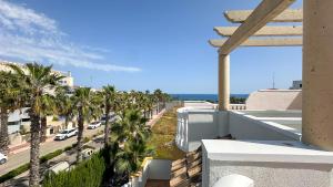 a view from the balcony of a building with palm trees at NEW Villa Cabo Roig Coco-Mat 2 in Playas de Orihuela