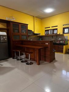 a kitchen with a wooden bar with stools at Tumaninah Villa in Lembang