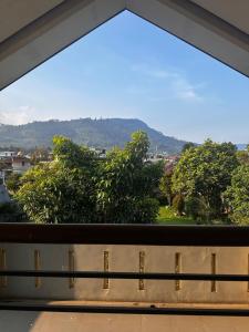 a window with a view of trees and mountains at Tumaninah Villa in Lembang