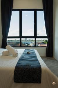 a bedroom with a bed with a large window at Rumaho Upton by Elica Kuching in Kuching +178 photos