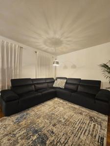 a living room with a black couch and a rug at Antica Dimora Confine in Mira