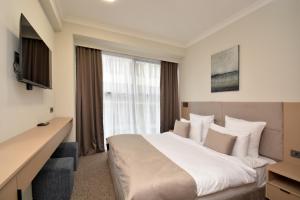 a hotel room with a large bed and a window at BM Avenue Hotel in Yerevan