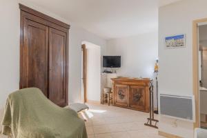 a living room with a chair and a television at My Alba in Jaujac