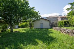 a small white building in a yard with a tree at My Alba in Jaujac