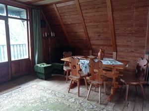 a dining room with a table and chairs in a cabin at domek Kaszuby nad jeziorem in Chmielno +7 photos