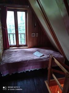 a small bed in a room with a window at domek Kaszuby nad jeziorem in Chmielno