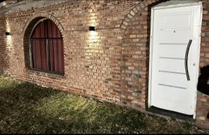 a brick wall with a white door and a window at Cabaña San Antonio2 in Tinogasta