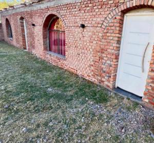 a brick building with a white door and windows at Cabaña San Antonio2 in Tinogasta