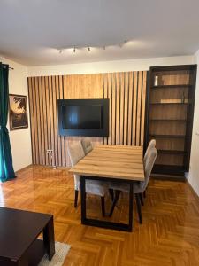 a dining room with a wooden table and a television at Vanila Ub in Ub