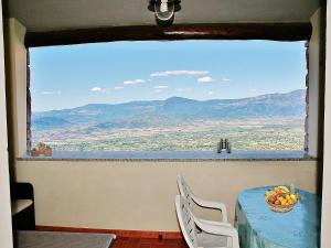 a table with a bowl of fruit and a view of mountains at Sunset Baunei in Baunei