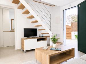 a living room with a tv and a staircase at Casa de vacances Els Arbocers in Cala Blanca