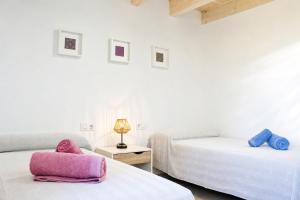 a white room with two beds and a lamp at Casa de vacances Els Arbocers in Cala Blanca