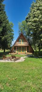 a large wooden house in a field with trees at Careva staza in Nikšić